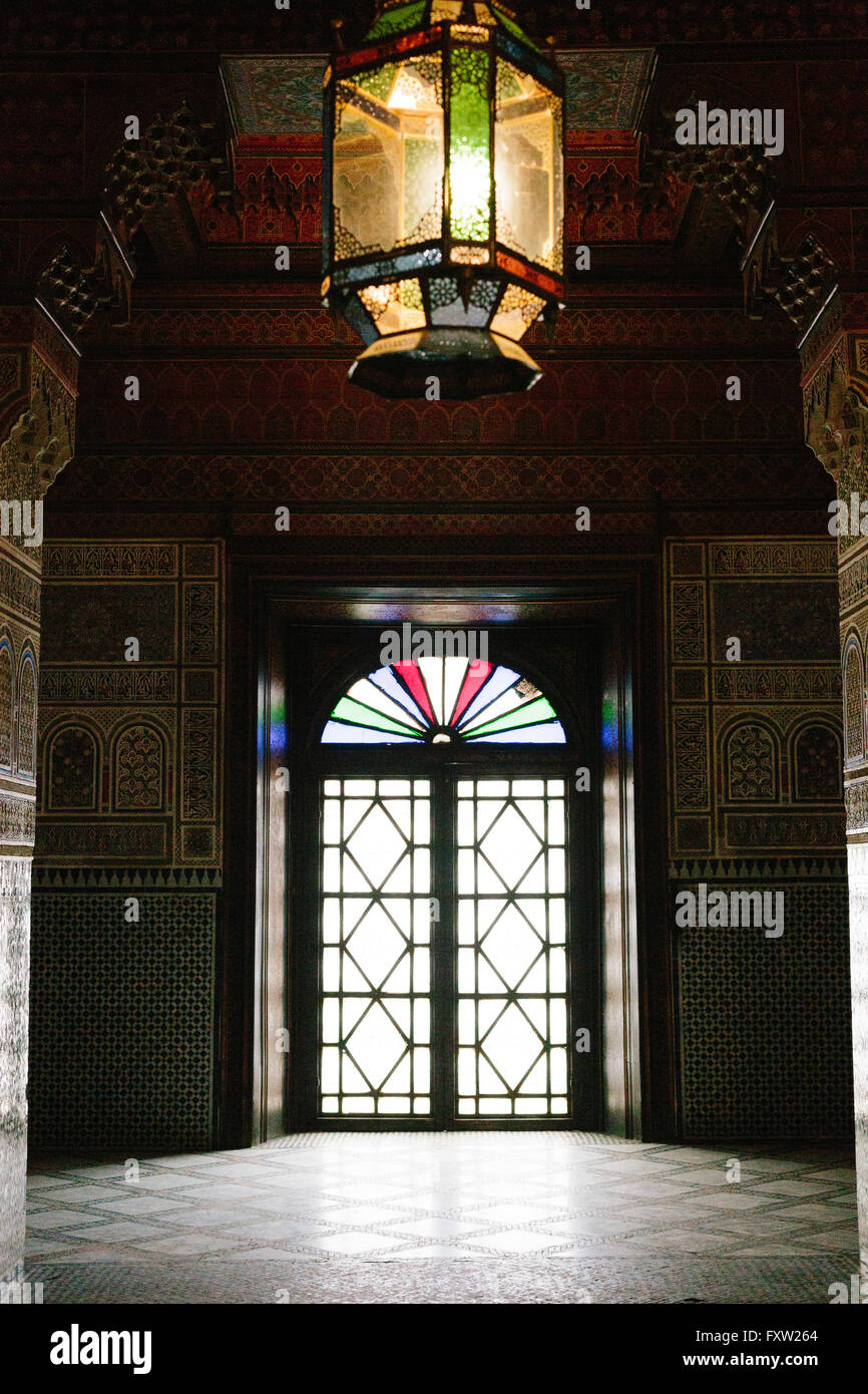 Inondations en lumière à travers les fenêtres des stainglass Dar Si Said, remplissant l'obscurité avec la lumière. riad Banque D'Images