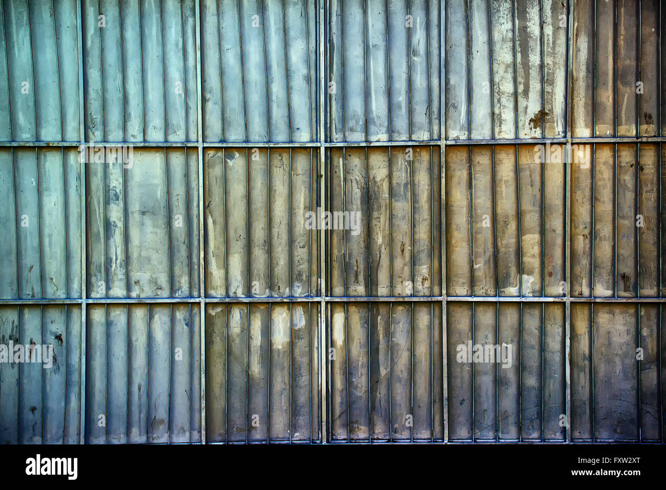 Rusty metal aluminium oxydé garage chormé mur, la texture de la surface métallique avec des barres d'armature verticale et horizontale Banque D'Images