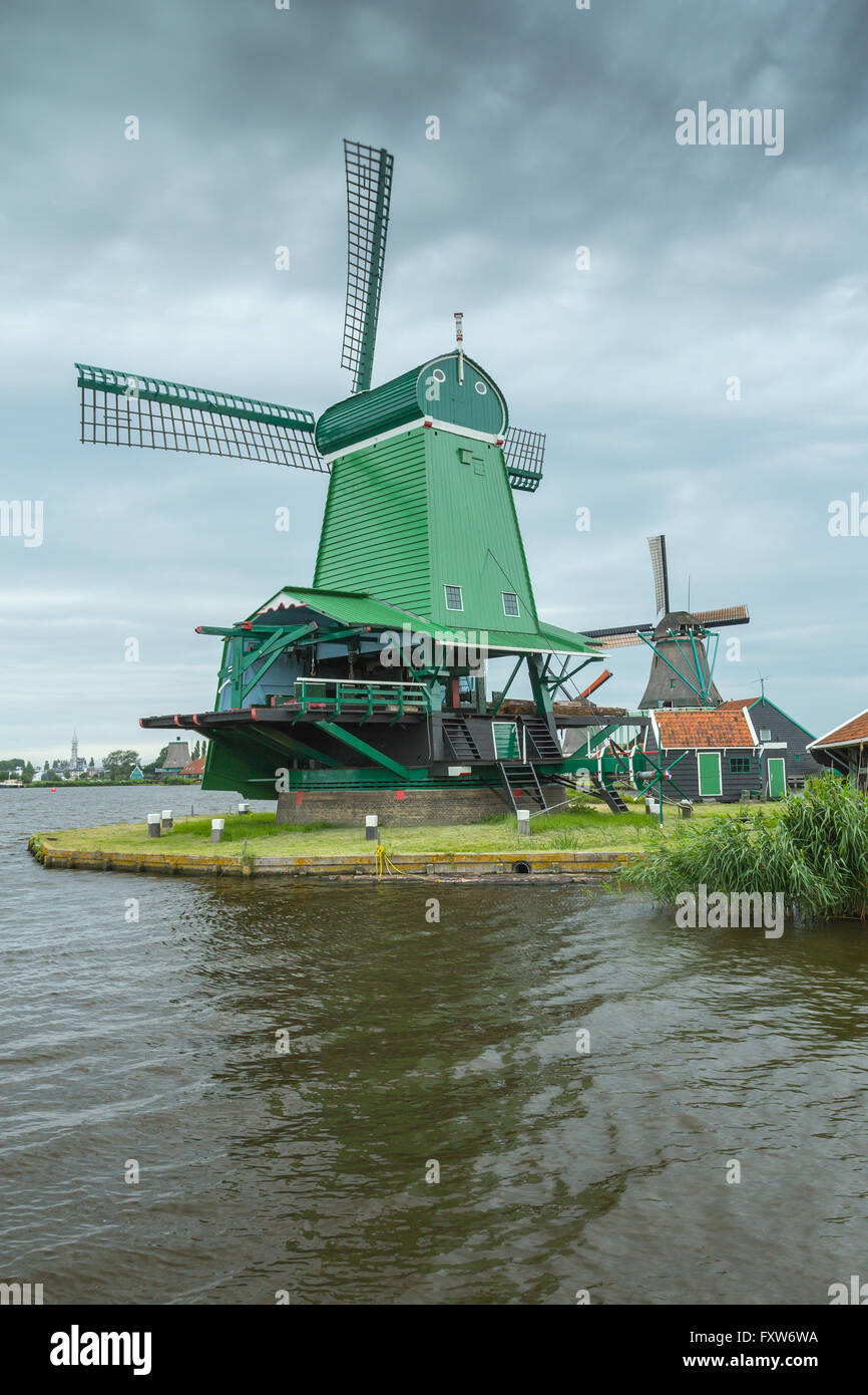 Moulin à vent traditionnel en Pays-bas (Zaanse Schans). Le Moulin Vert est debout près du lac. Banque D'Images