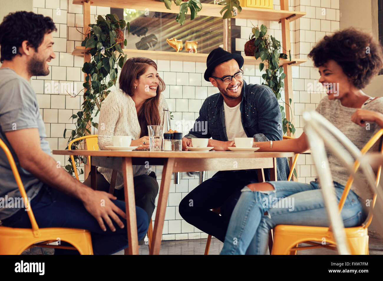 Les jeunes ayant un grand temps dans le café. Les amis de sourire et assis dans un café, boire du café et profiter ensemble. Banque D'Images