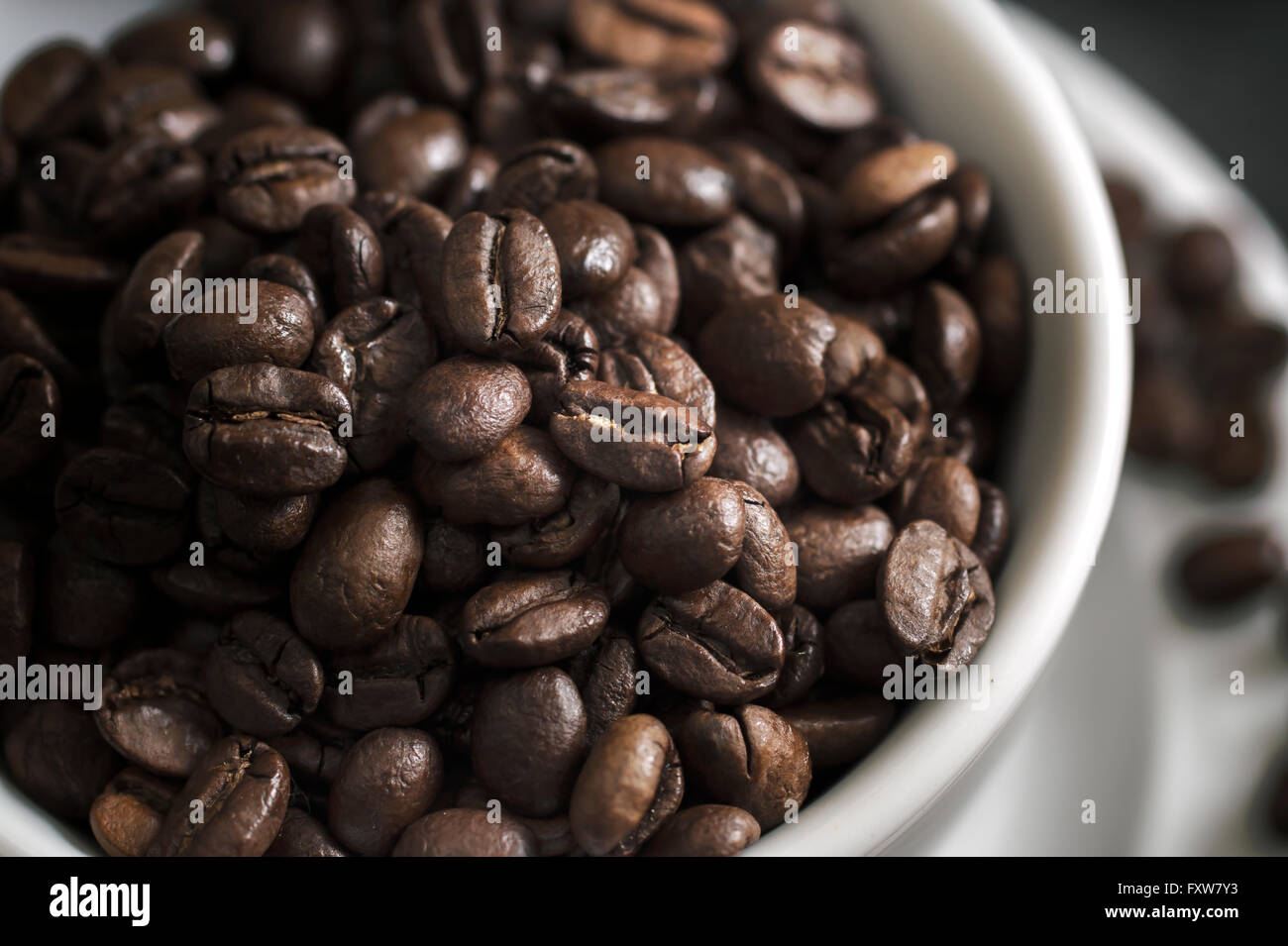 Tasse de café débordant de grains de café, faible profondeur de champ Banque D'Images