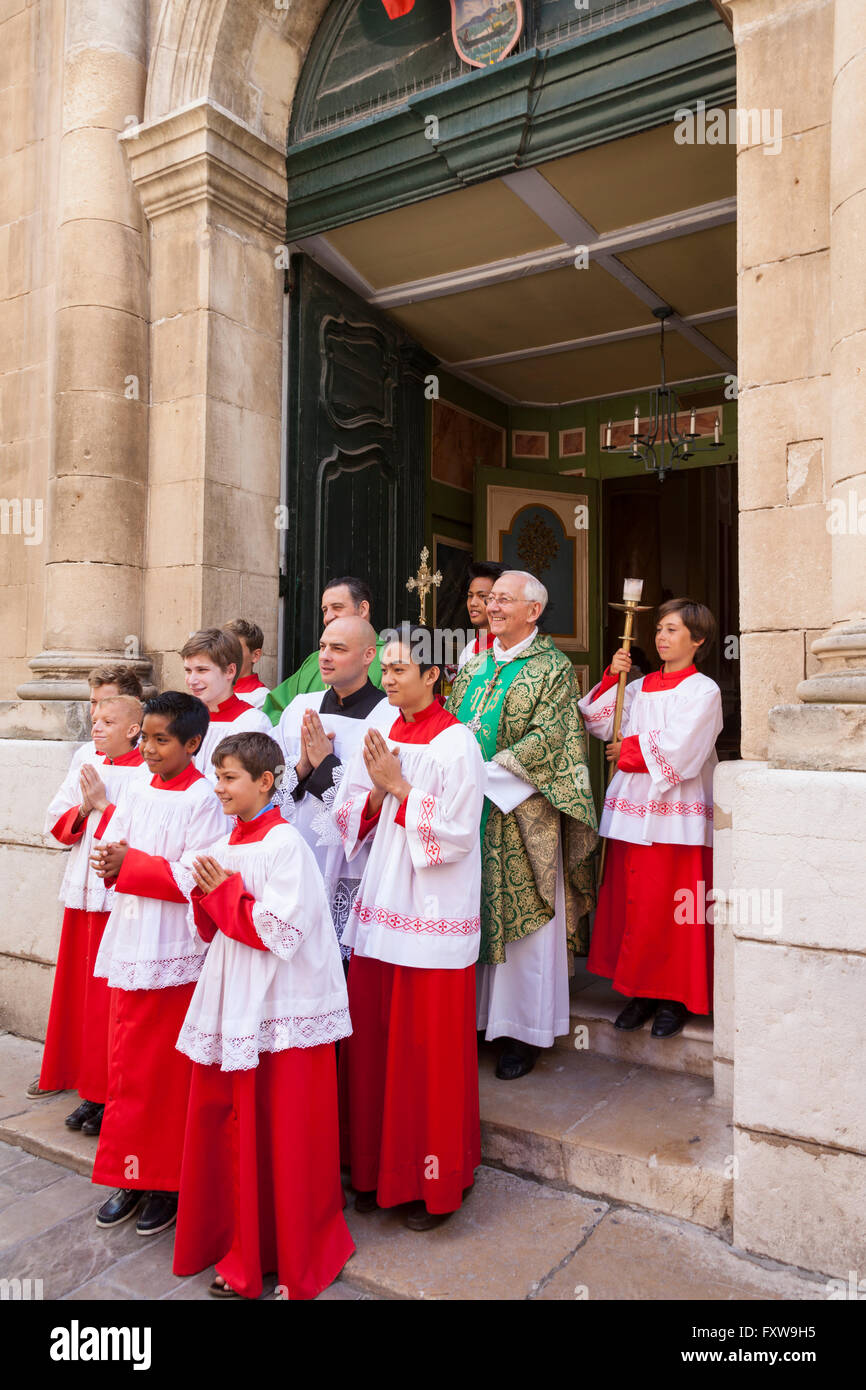 Choeur de garçons et de prêtre à l'extérieur de Notre Dame de l'Assomption, Saint Tropez, France Banque D'Images