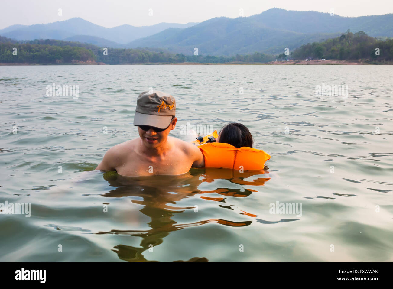Phayao, en Thaïlande - le 15 avril 2016. L'homme à la rivière d'aider les femmes en raison d'accidents de noyade en portant un gilet de sauvetage et escorté hors de l'eau . Banque D'Images