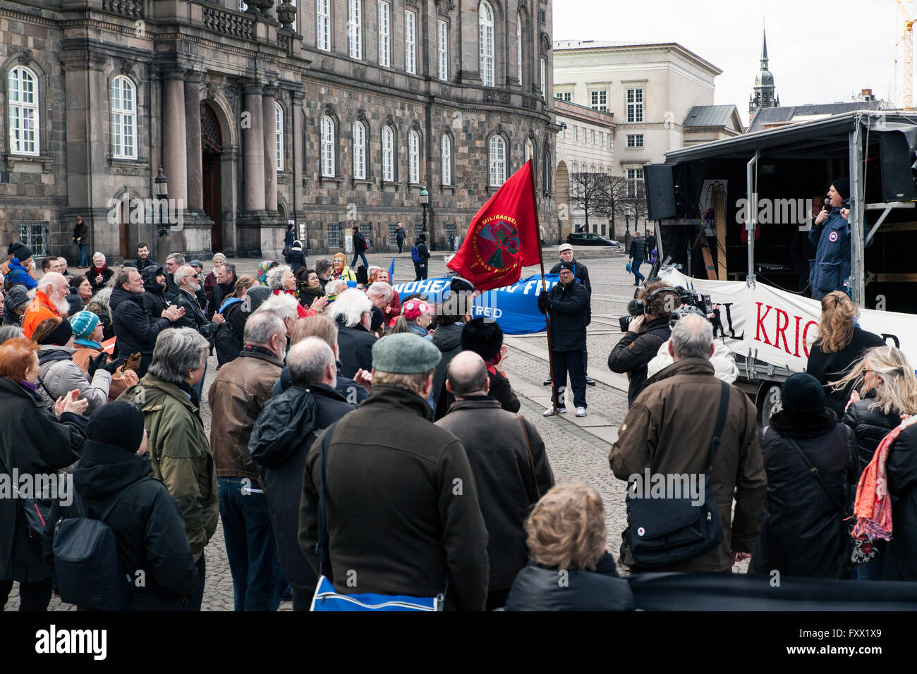 Copenhague, Danemark, 19 avril 2016. Les manifestants à la place du Parlement de manifester contre un projet de loi en cours de négociation au Parlement simultanée, Christiansborg (arrière-plan), qui permettra d'accroître la participation militaire danois dans la lutte contre l'Etat islamique en Syrie. Le projet de loi a été adopté et signifie que les combattants de l'air F-16, avion de transport Hercules et les Forces spéciales seront bientôt déployés dans la guerre. Credit : OJPHOTOS/Alamy Live News Banque D'Images