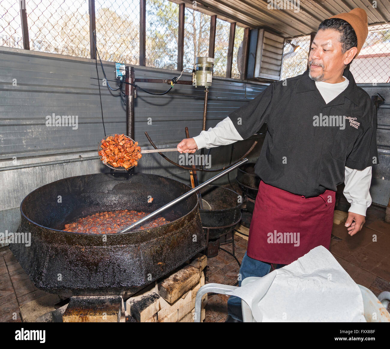 Darby Guillory cuisiniers en place un lot de son célèbre cracklins...de porc frits fatback. Lake Charles, LA. Banque D'Images