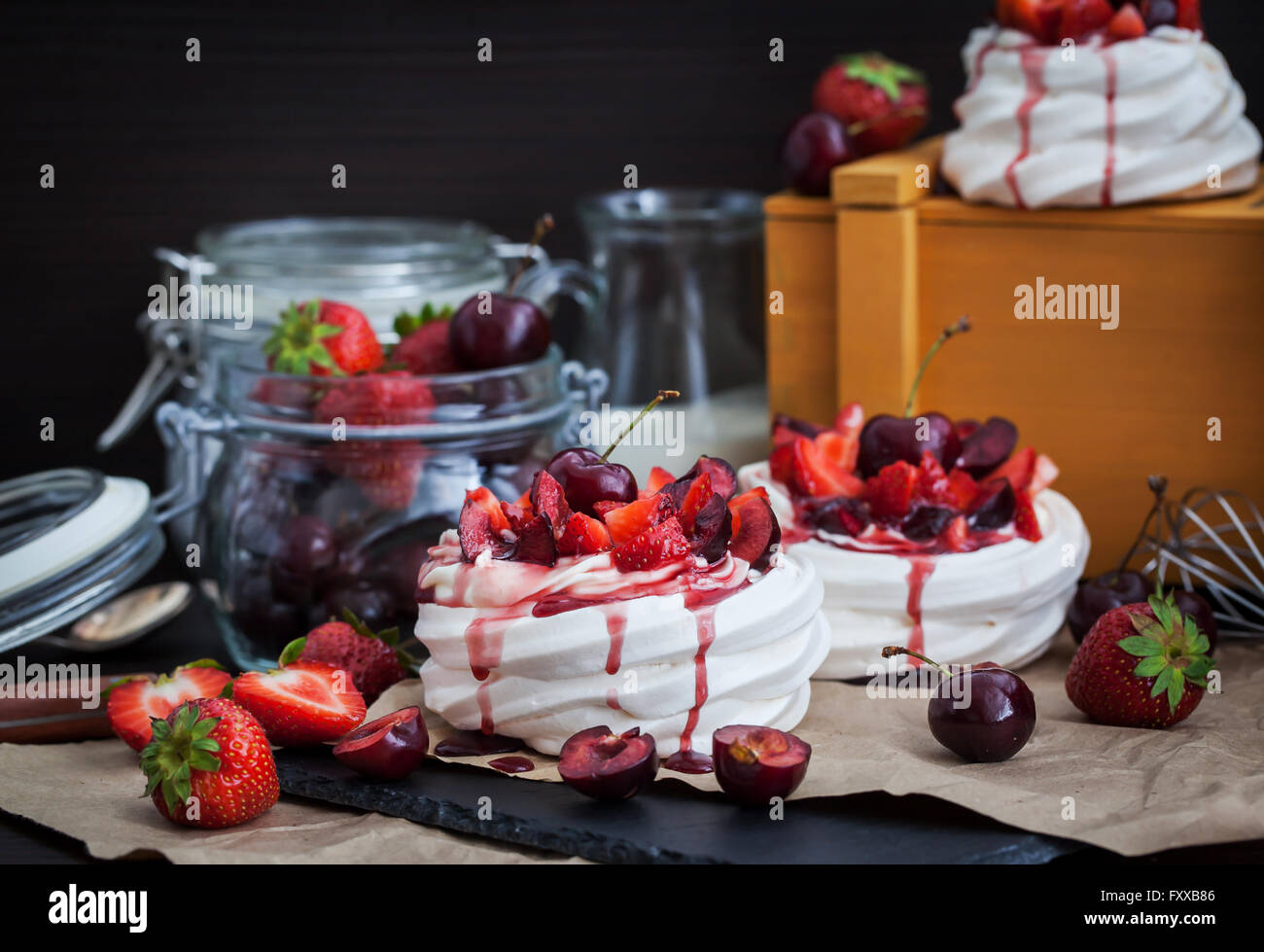 Partie de mini Pavlova meringuée gâteau décoré avec des fraises fraîches et cherry Banque D'Images