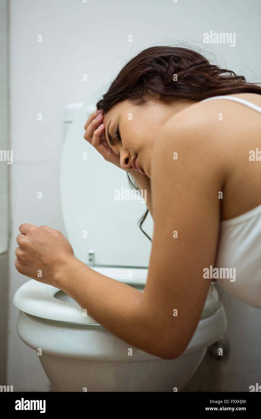 Jeune femme sur le point de vomir dans une commode toilettes Banque D'Images Jeune femme sur le point de vomir dans une commode toilettes Banque D'Images