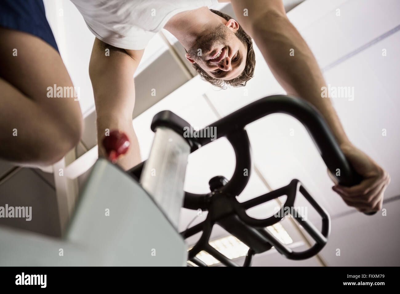 Man working out on exercise bike at spinning class Banque D'Images