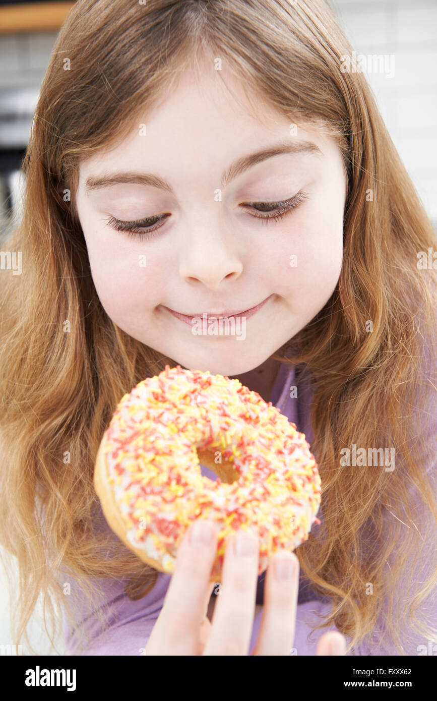 Young Girl Eating Donut sucrées pour le goûter Banque D'Images