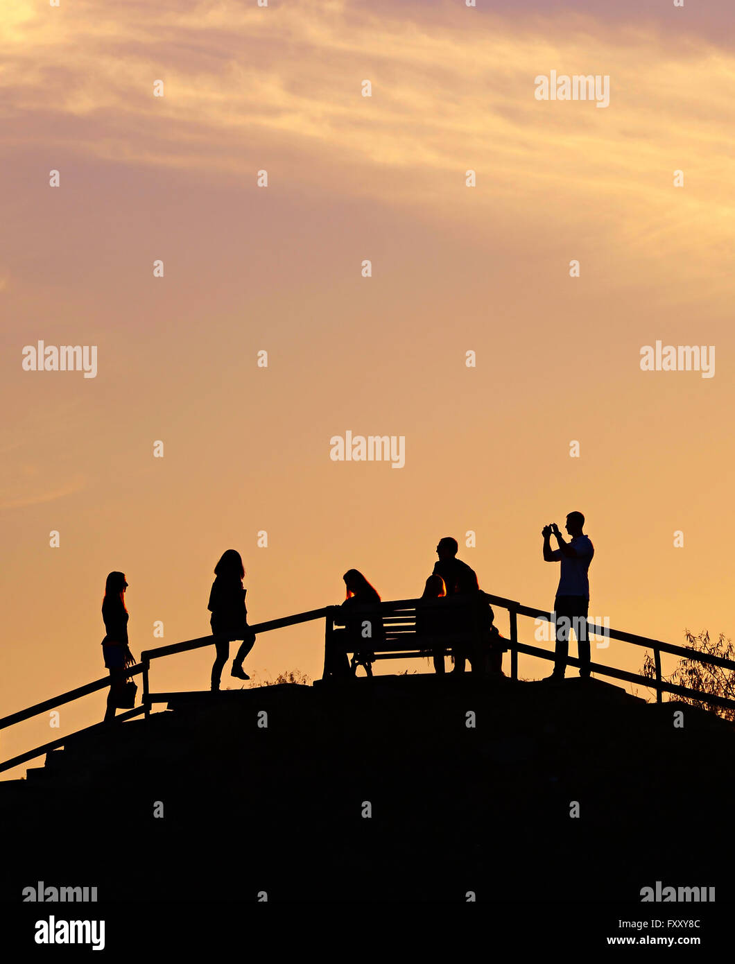 Silhouette d'un peuple sur une colline dans un parc au coucher du soleil Banque D'Images