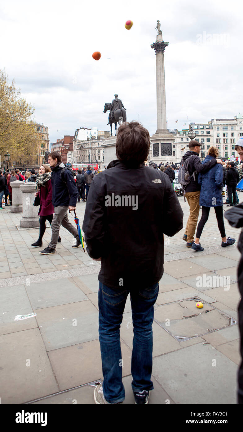 Un homme jongle avec des balles sur Trafalgar Square, symbole de la façon dont il voit le gouvernement juggling la justice en Palestine. Banque D'Images