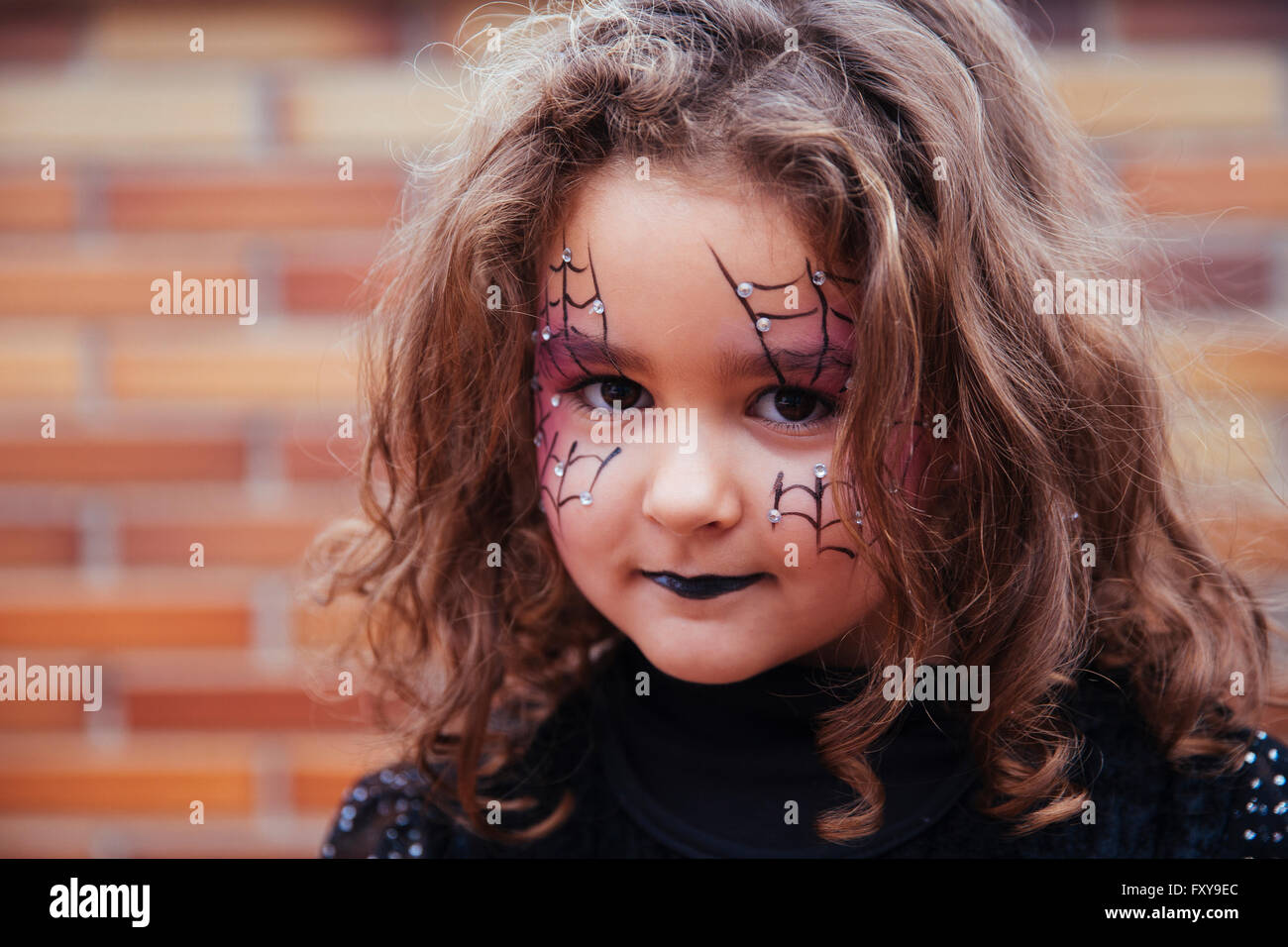 Petite fille avec Spider web peint sur le visage à la caméra à. Halloween Banque D'Images