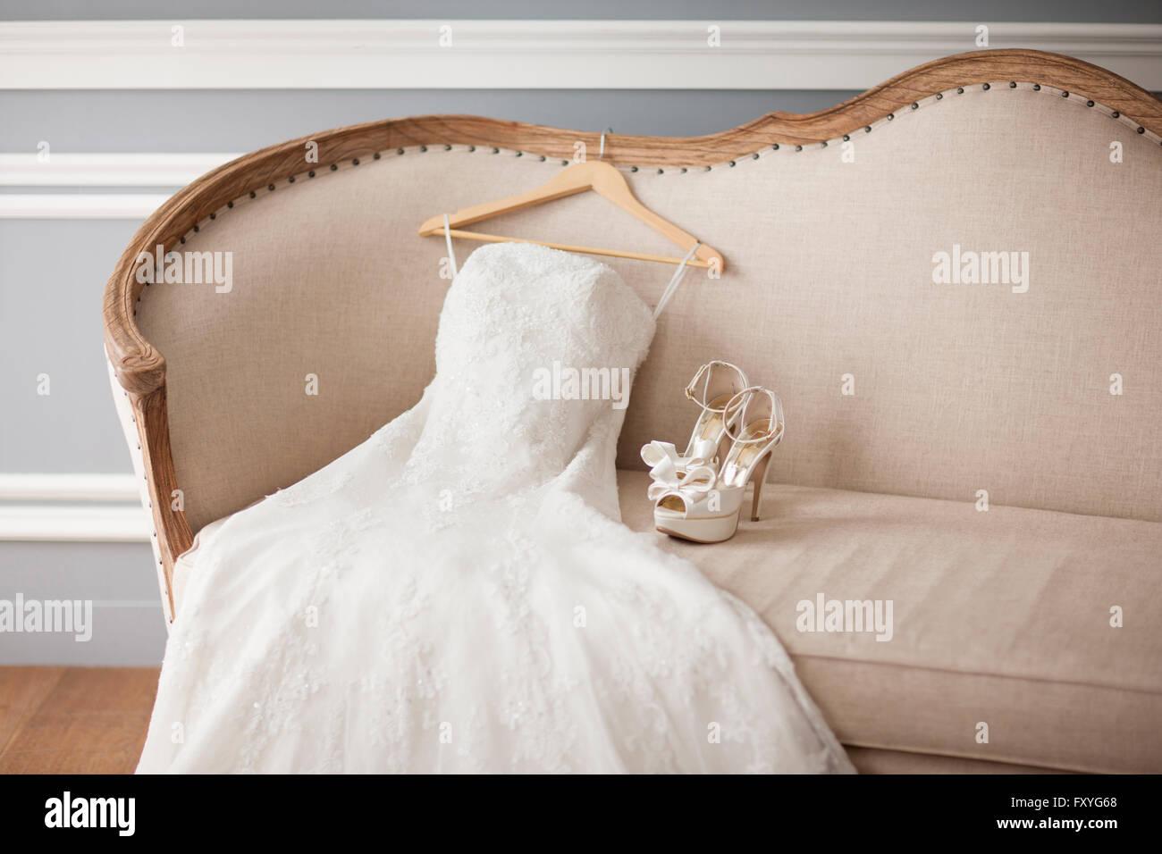 Robe de mariage et de hauts talons sur un canapé Banque D'Images