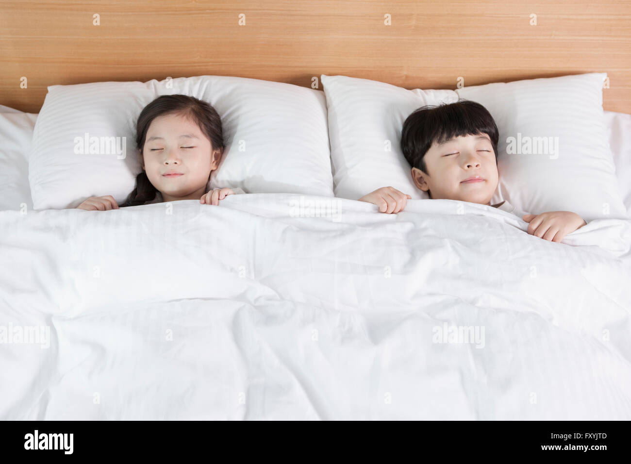 High angle d'enfants dans le sommeil sur le lit à la chambre d'hôtel Banque D'Images