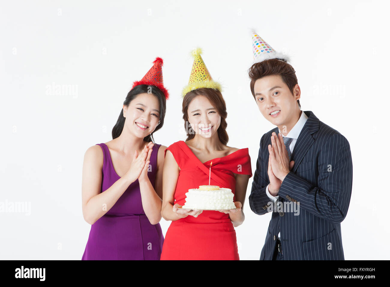 Portrait de trois jeunes gens avec un gâteau at party Banque D'Images