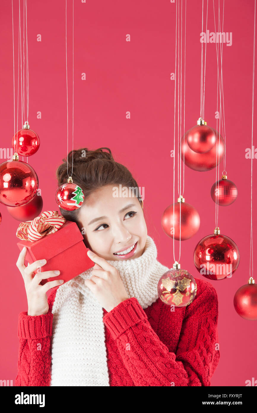 Portrait of young Smiling woman holding a présent fort avec des boules de Noël Banque D'Images