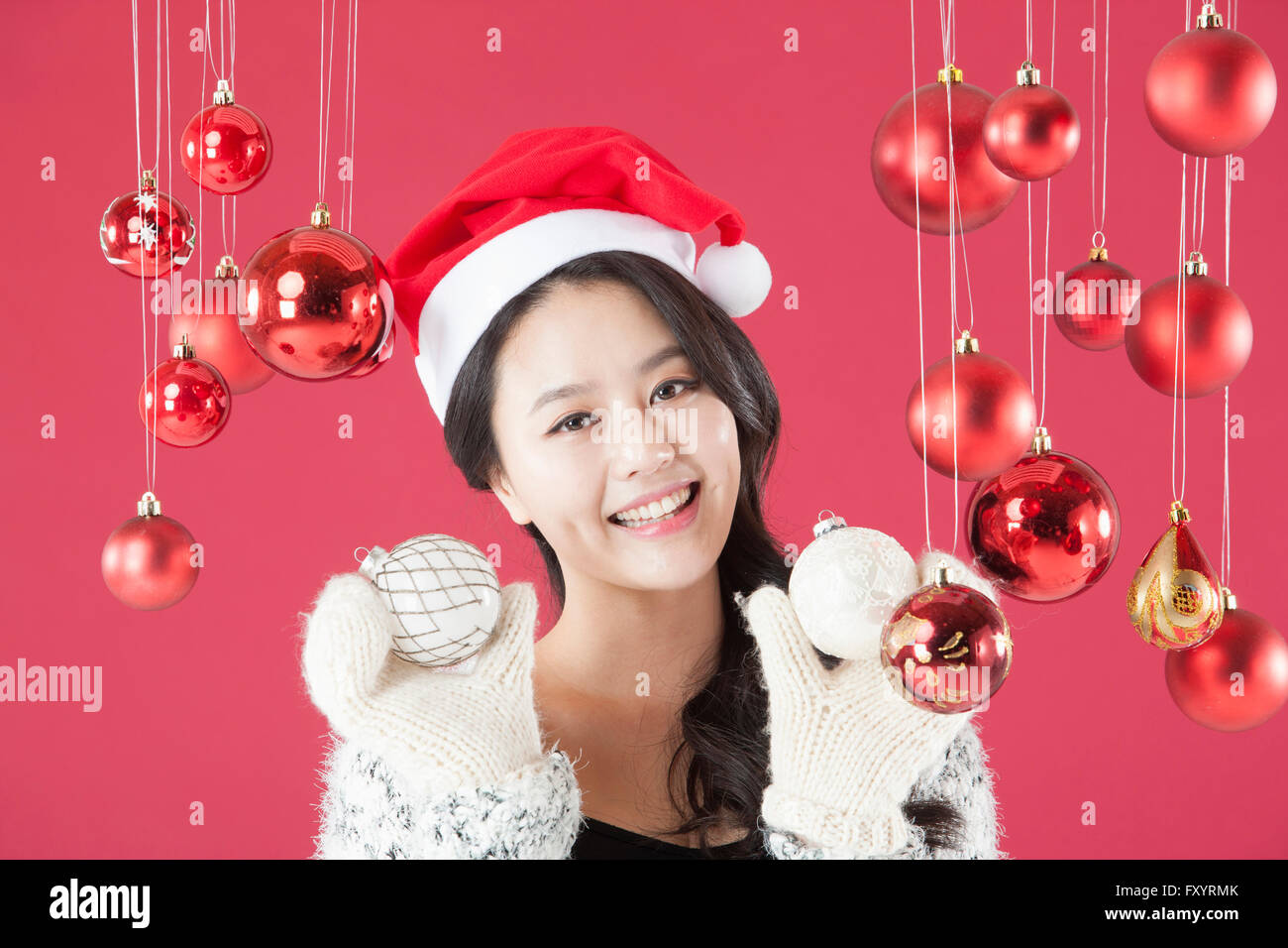 Portrait of young smiling woman holding Christmas balls fixant à l'avant Banque D'Images