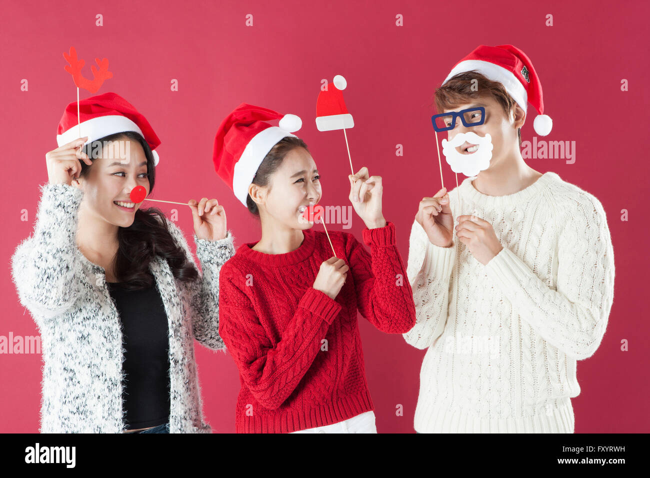 Portrait de trois jeunes smiling people at Christmas party Banque D'Images