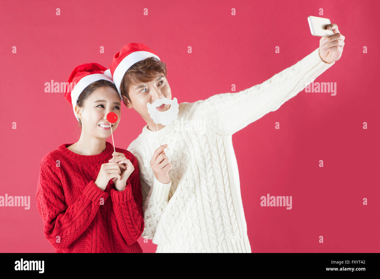 Portrait of young smiling couple posant pour la fête de Noël à selfies Banque D'Images