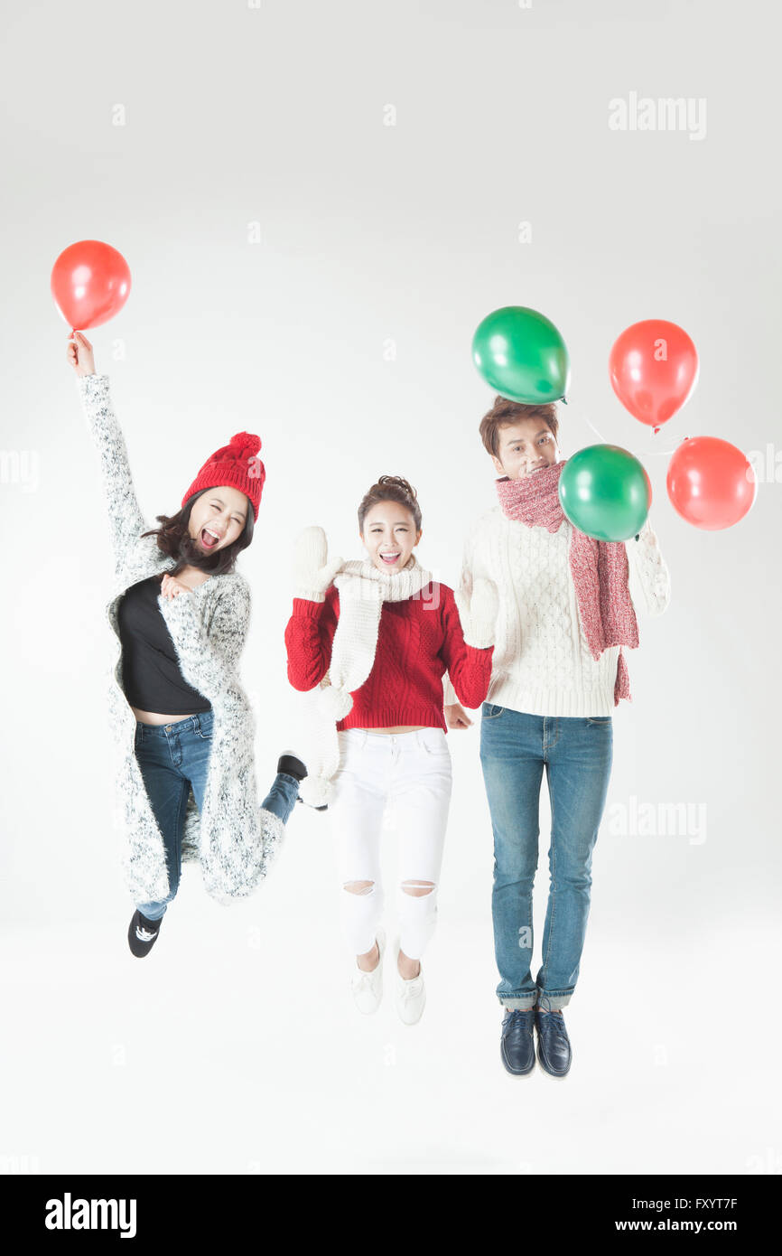 Trois jeunes smiling people jumping with balloons Banque D'Images