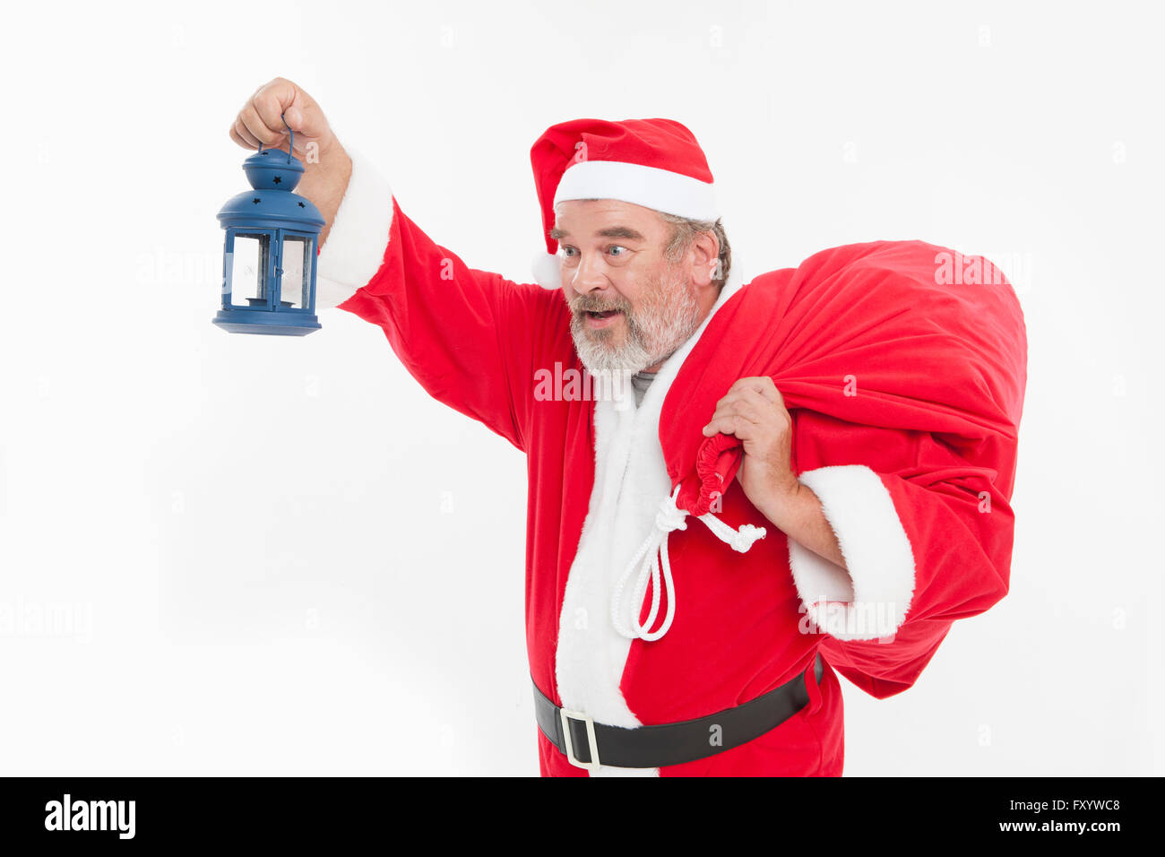 Portrait of Santa tenant une lanterne et présenter bag Banque D'Images
