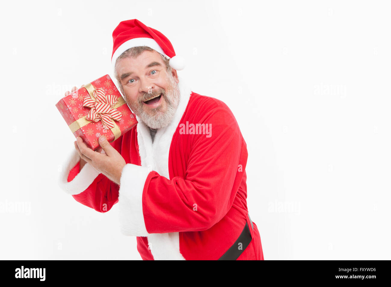 Portrait of smiling Santa posant avec un présent fort fixant à l'avant Banque D'Images
