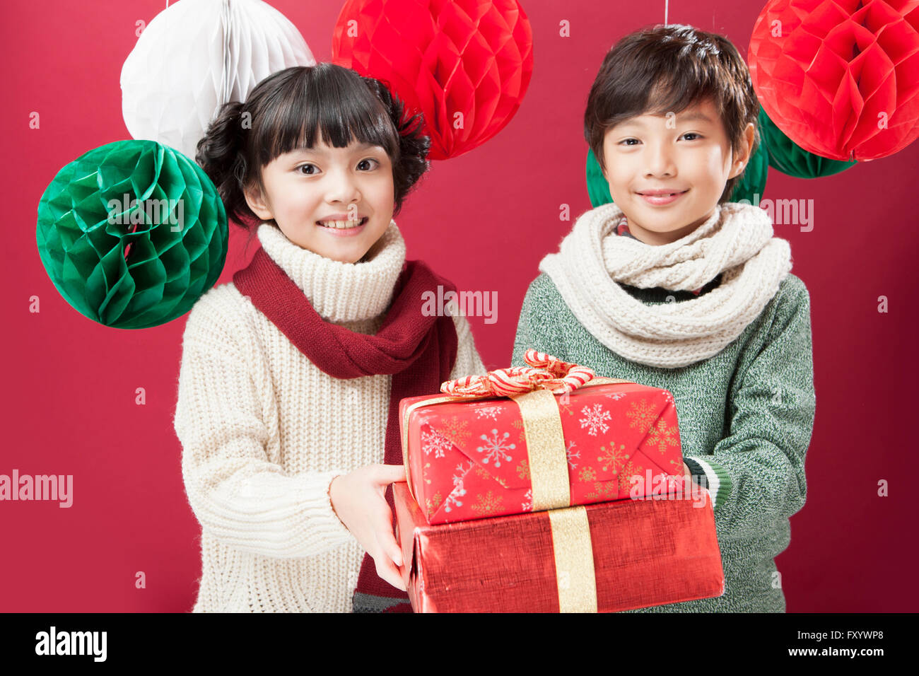 Portrait of smiling boy and girl holding present avant de boîtes Banque D'Images