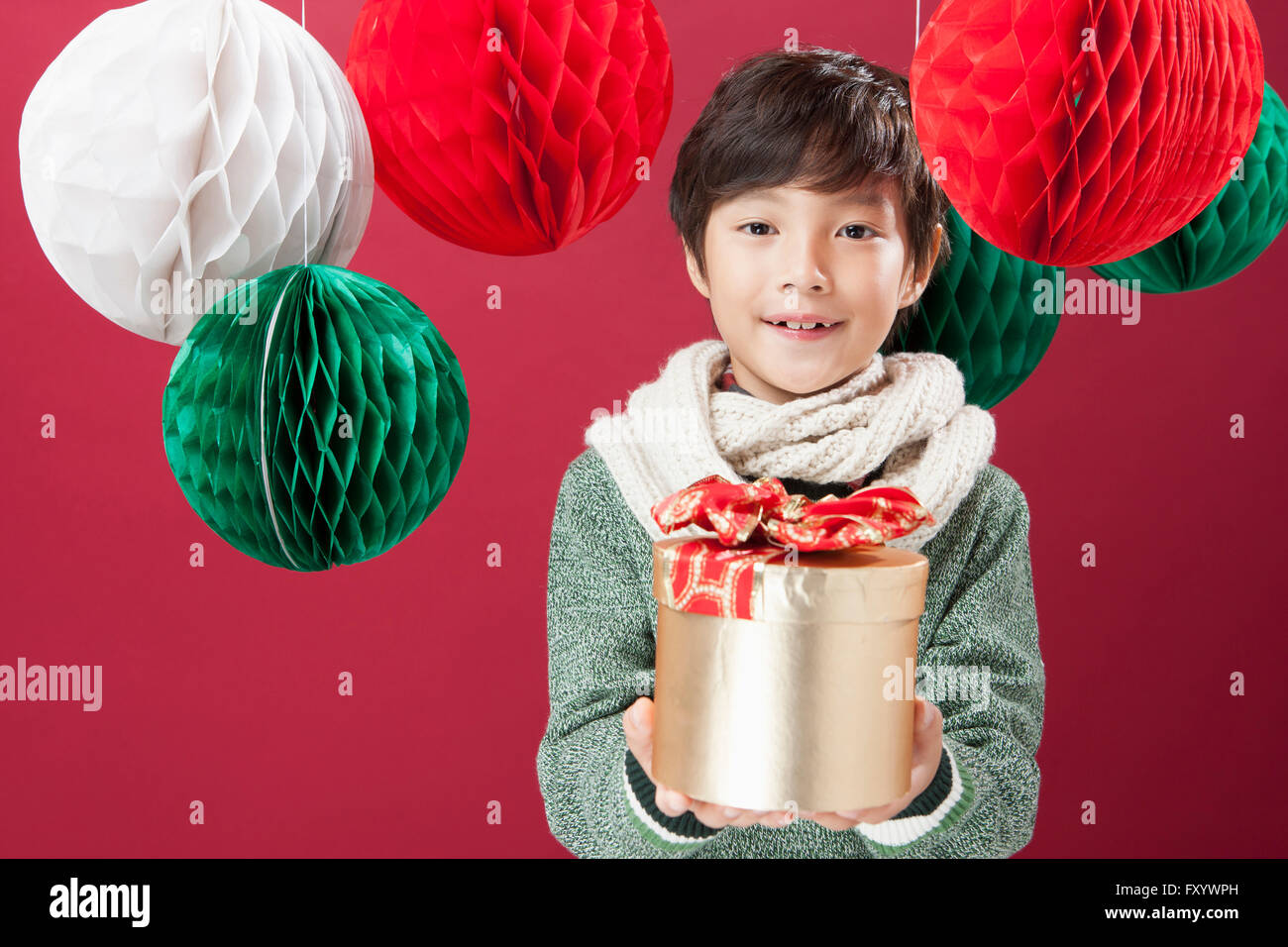 Portrait of smiling boy holding a présent fort avec des ornements de Noël fixant à l'avant Banque D'Images