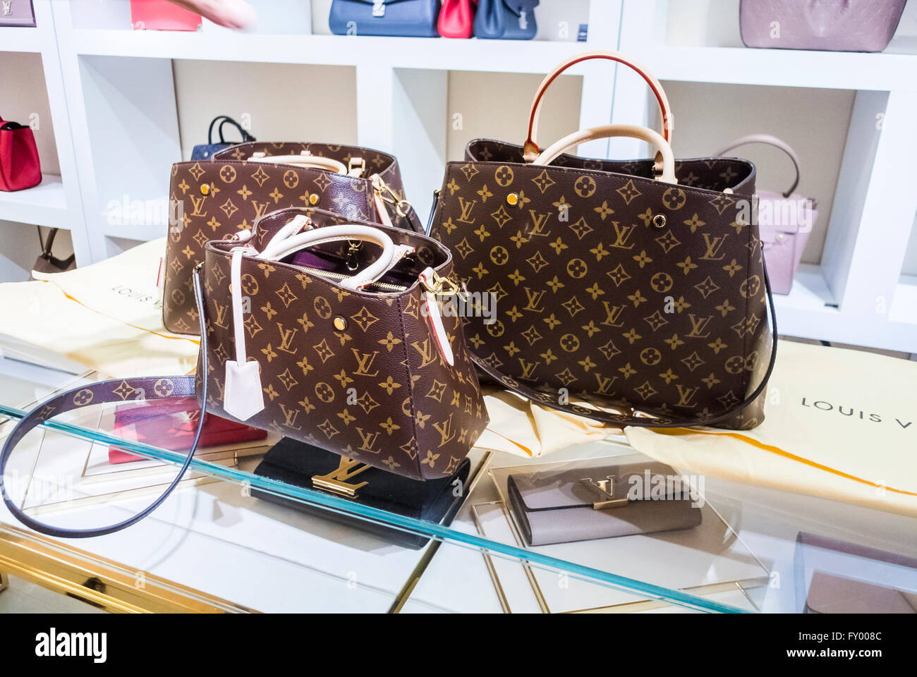 Shoppers with Louis Vuitton bags in Oxford Street London, pass bus with  advert for fashion outlet boohoo Stock Photo - Alamy