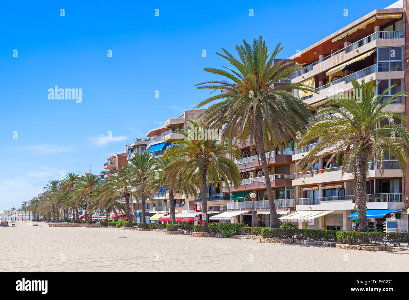Les bâtiments modernes et de palmiers sur la rue côtière de Calafell resort town en journée ensoleillée. La région de Tarragone, Catalogne, Spai Banque D'Images