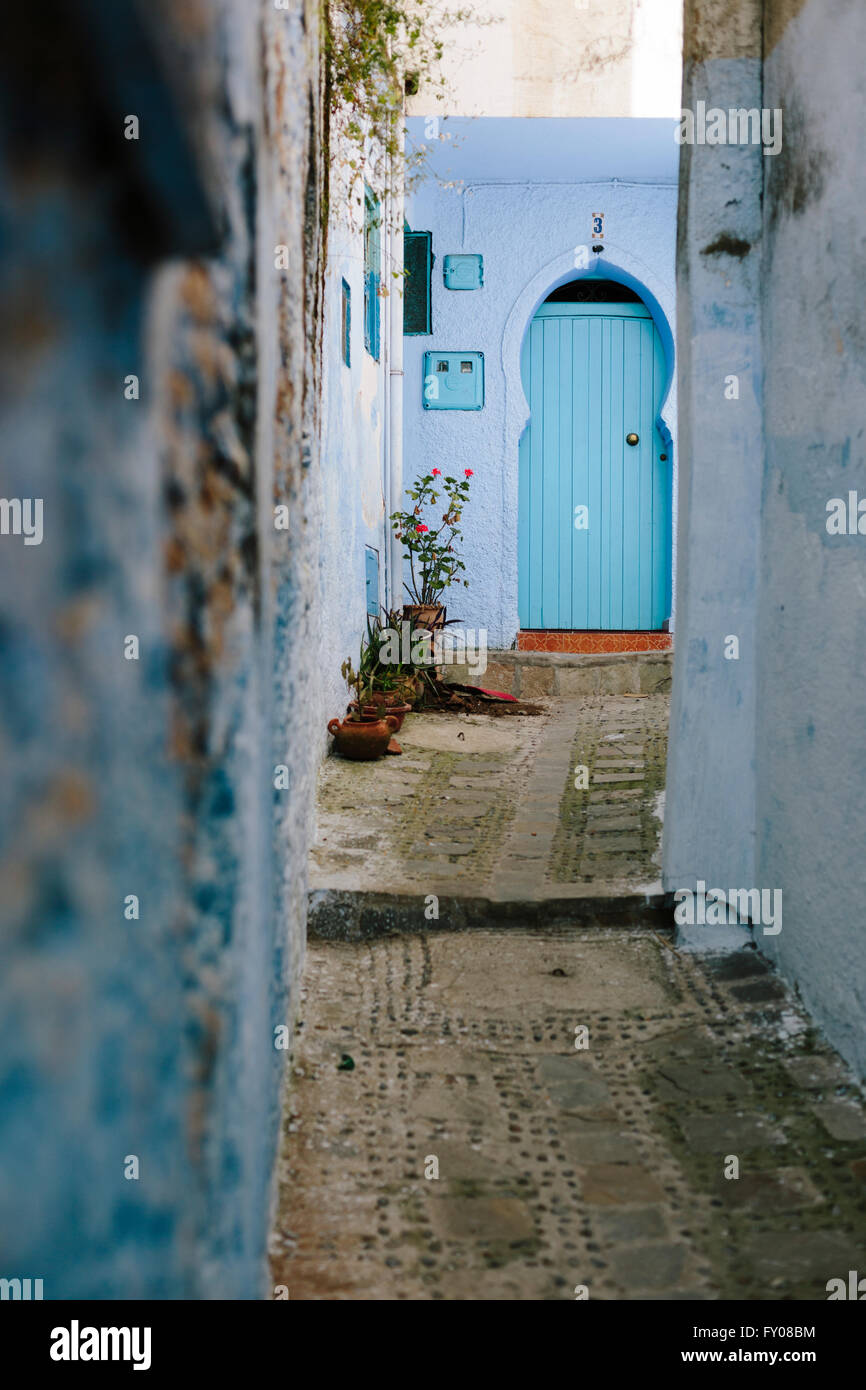 Un long chemin mène à une porte bleue à Chefchaouen. Banque D'Images