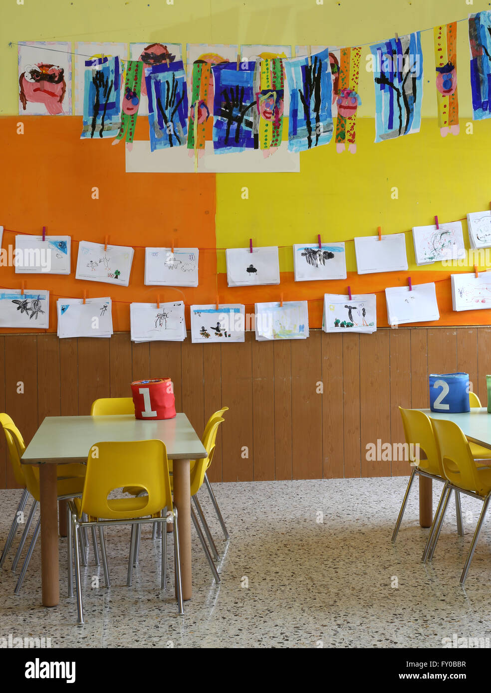 Classe de maternelle avec les chaises jaunes et des dessins d'enfants Banque D'Images