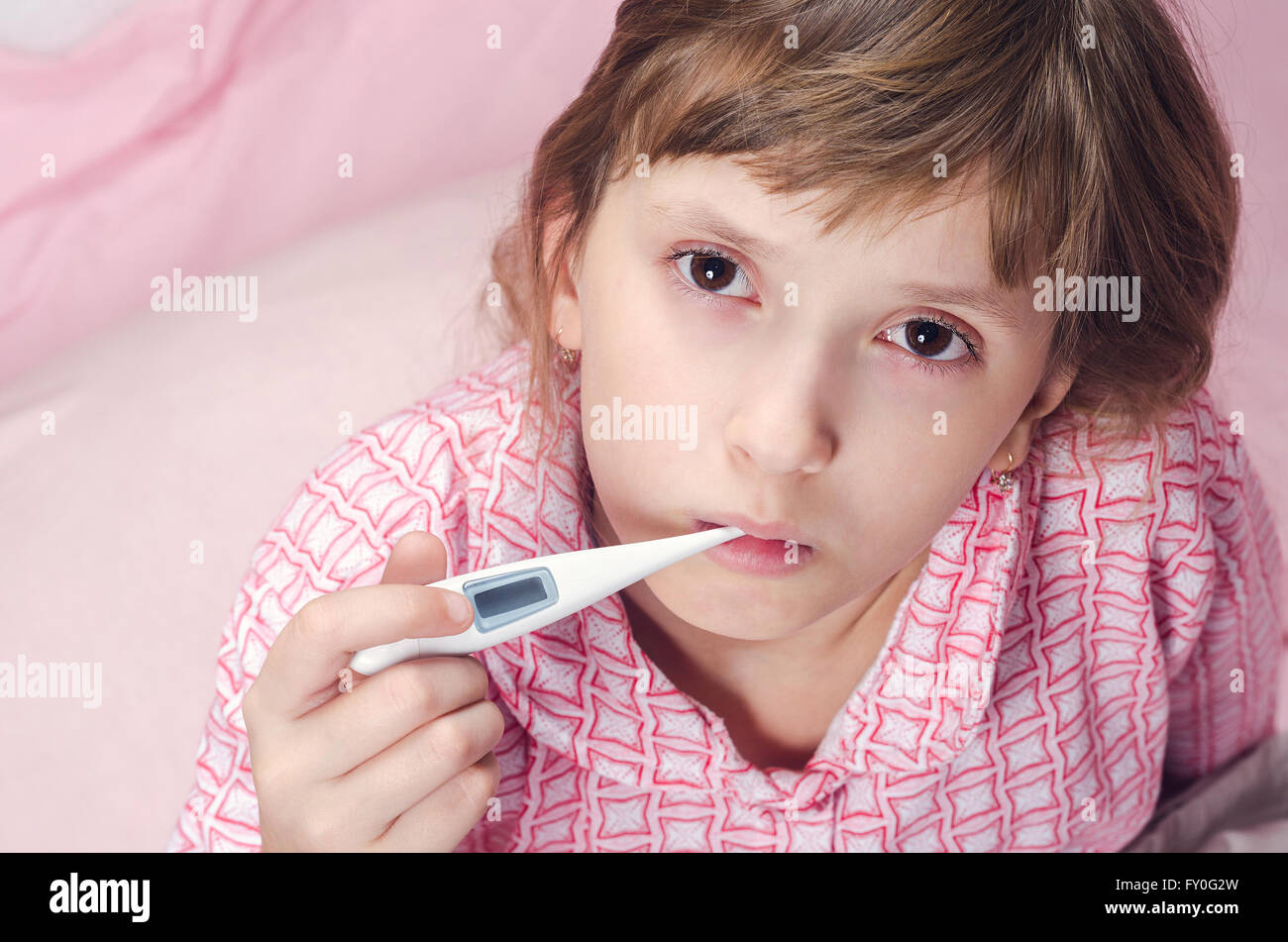 La jeune fille est titulaire d'un thermomètre dans une bouche Photo Stock -  Alamy