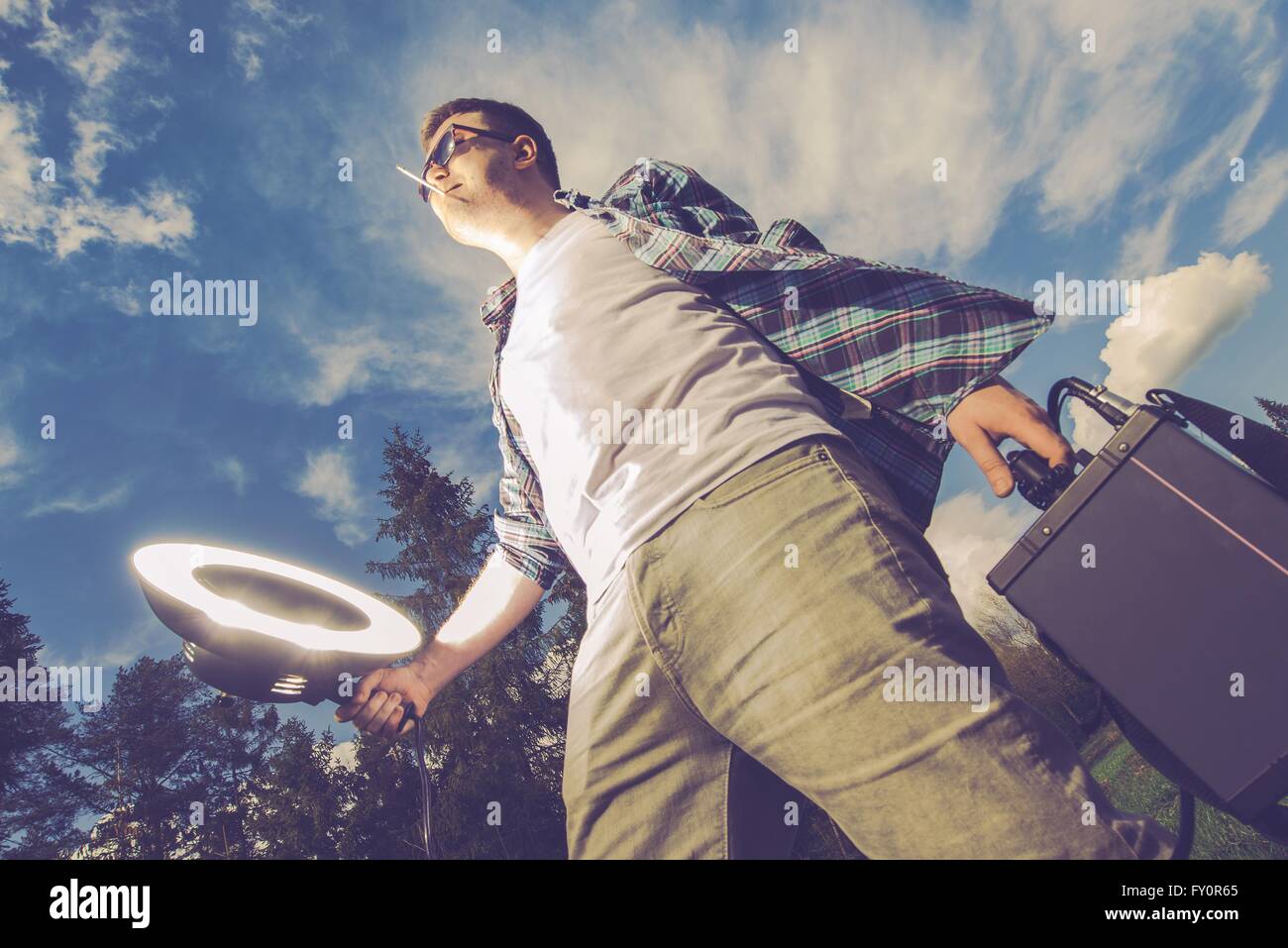 Lampe mobile Concept drôle Photographie Strobelight. Les jeunes hommes bénéficiant d'Storbe Light White la compassion et l'aide de lampe de poche Banque D'Images