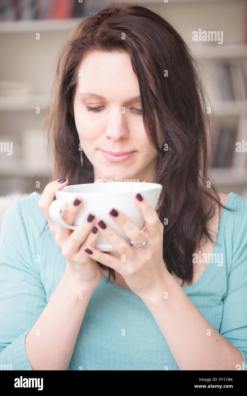 Woman holding tea cup dans votre intérieur. Concept de relaxation, prendre une pause et de tranquillité. Image Style de vie de contemplation. Banque D'Images