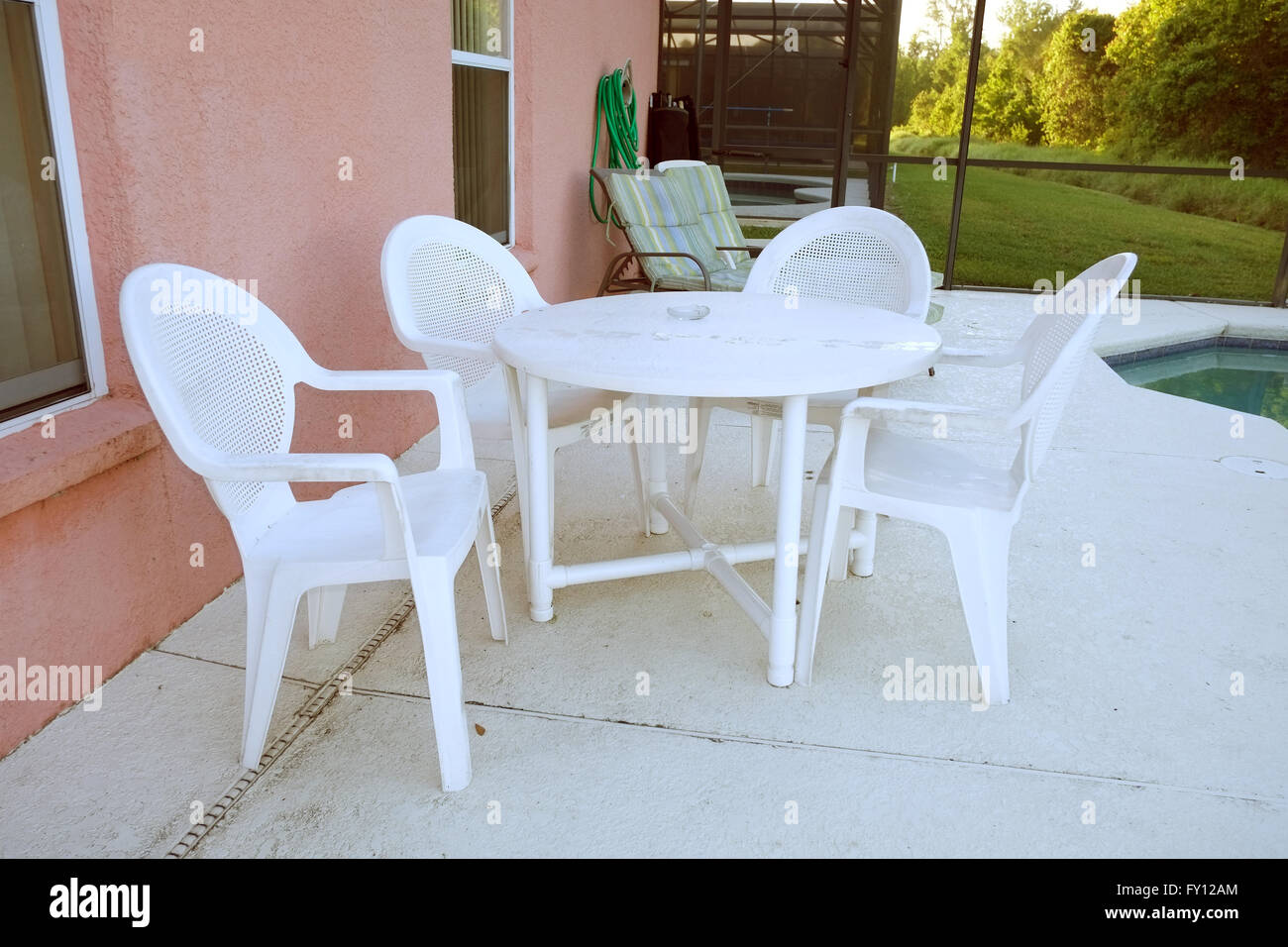 Tables et chaises en plastique blanc à l'extérieur une piscine Floride accueil utilisé pour location de vacances. 19 avril 2016 Banque D'Images