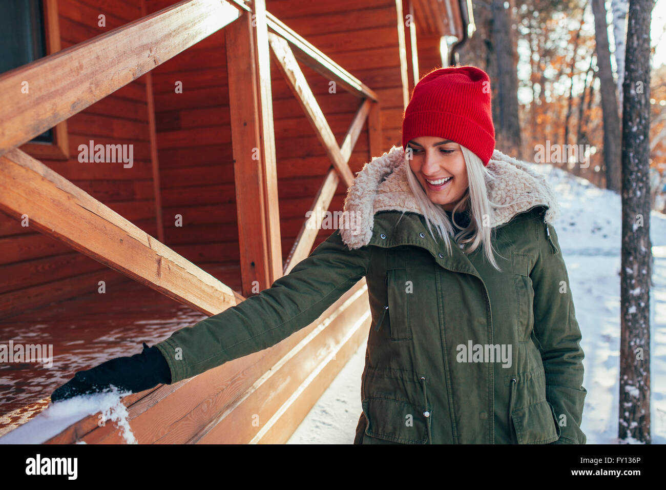 Belle jeune femme enlever la neige à partir de la rambarde Banque D'Images