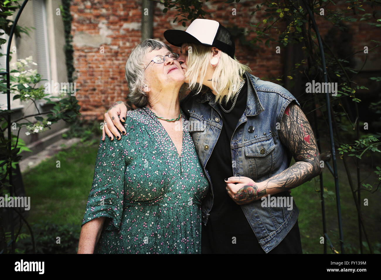 Fille mère embrasser tout en se tenant en arrière-cour Banque D'Images