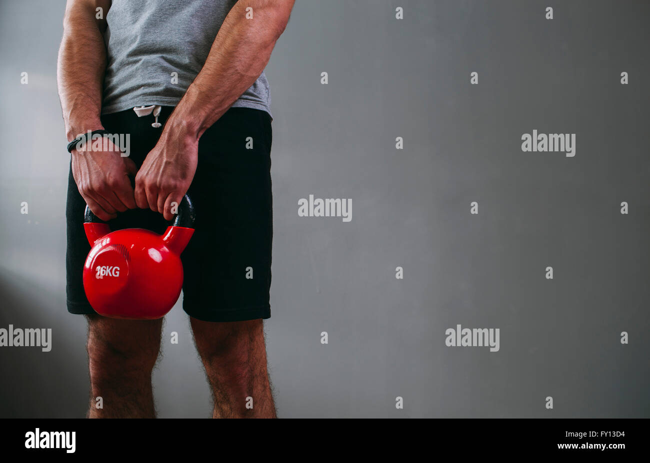 Portrait man lifting kettlebell at gym Banque D'Images