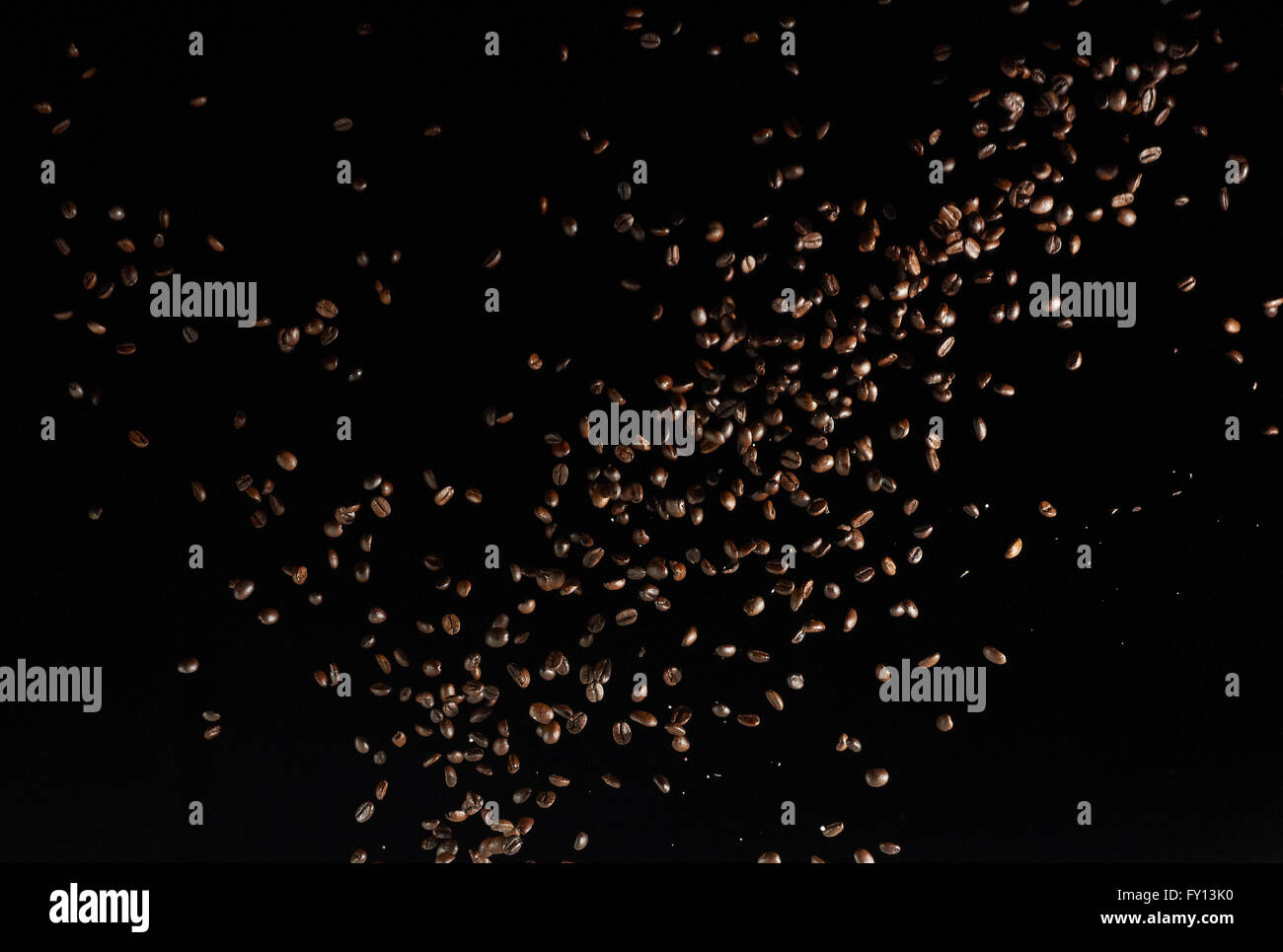 Les grains de café torréfié dans les airs sur fond noir Banque D'Images