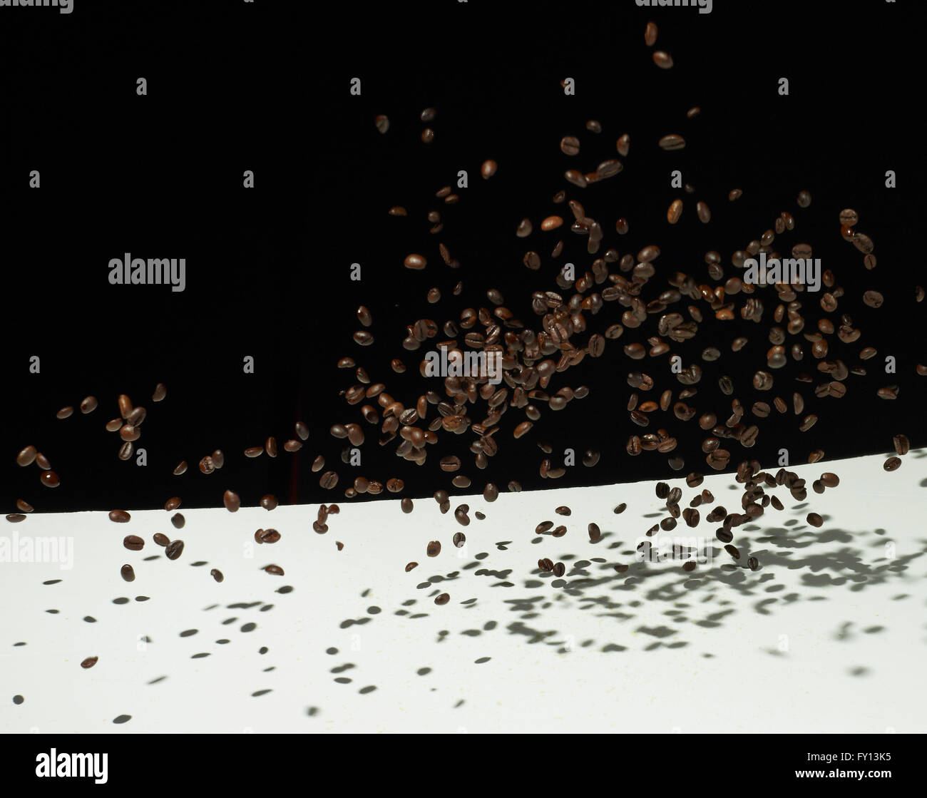 Les grains de café torréfié à la mi-air sur le tableau sur fond noir Banque D'Images