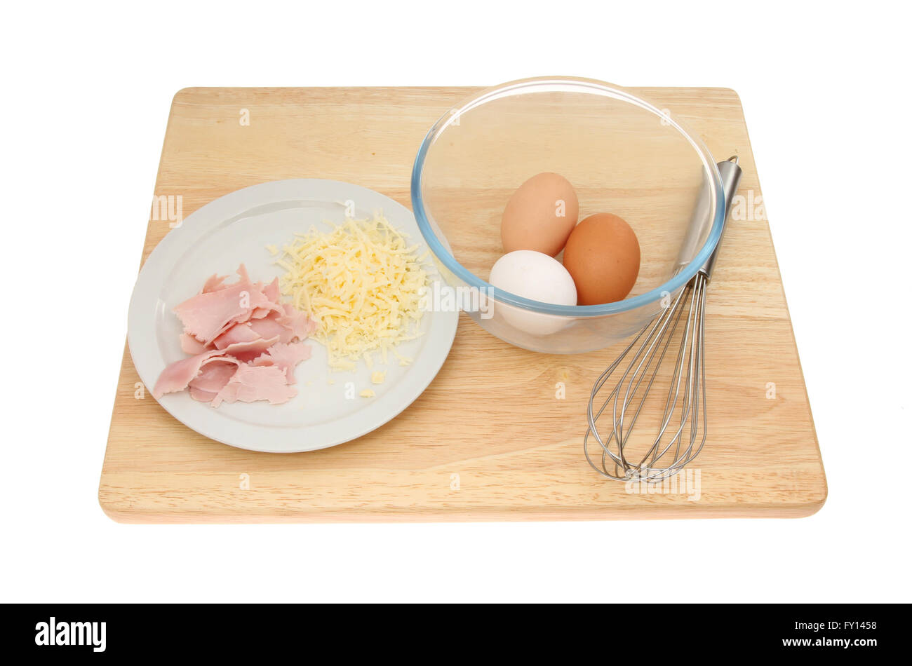 Ingrédients Omellete œufs, fromage et jambon avec un bol et fouetter sur une planche à découper en bois blanc isolé contre Banque D'Images