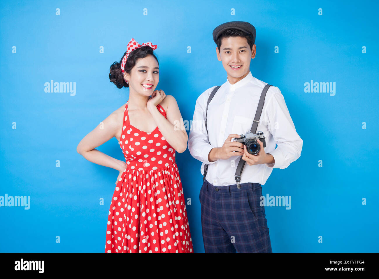 Young smiling woman and young smiling man avec un appareil photo en regardant/styles retro Banque D'Images