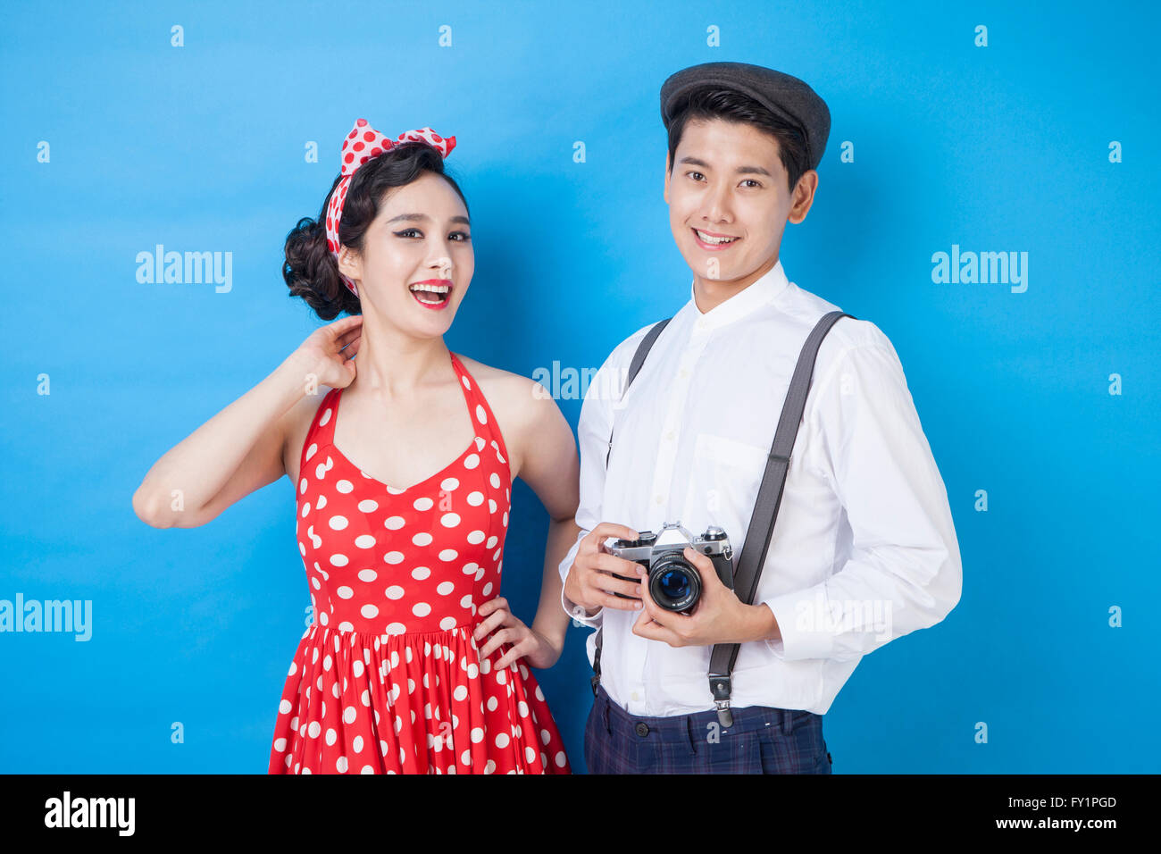 Young smiling woman and young smiling man avec un appareil photo à regarder/ Banque D'Images