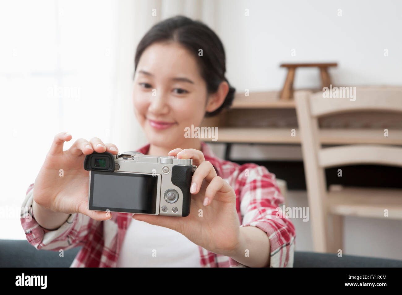 Portrait of young smiling woman taking photo d'elle-même avec un appareil photo numérique Banque D'Images