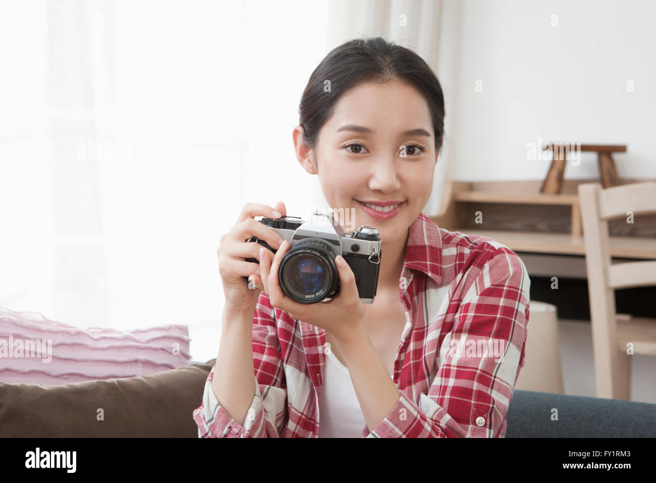 Portrait of young smiling woman with camera Banque D'Images