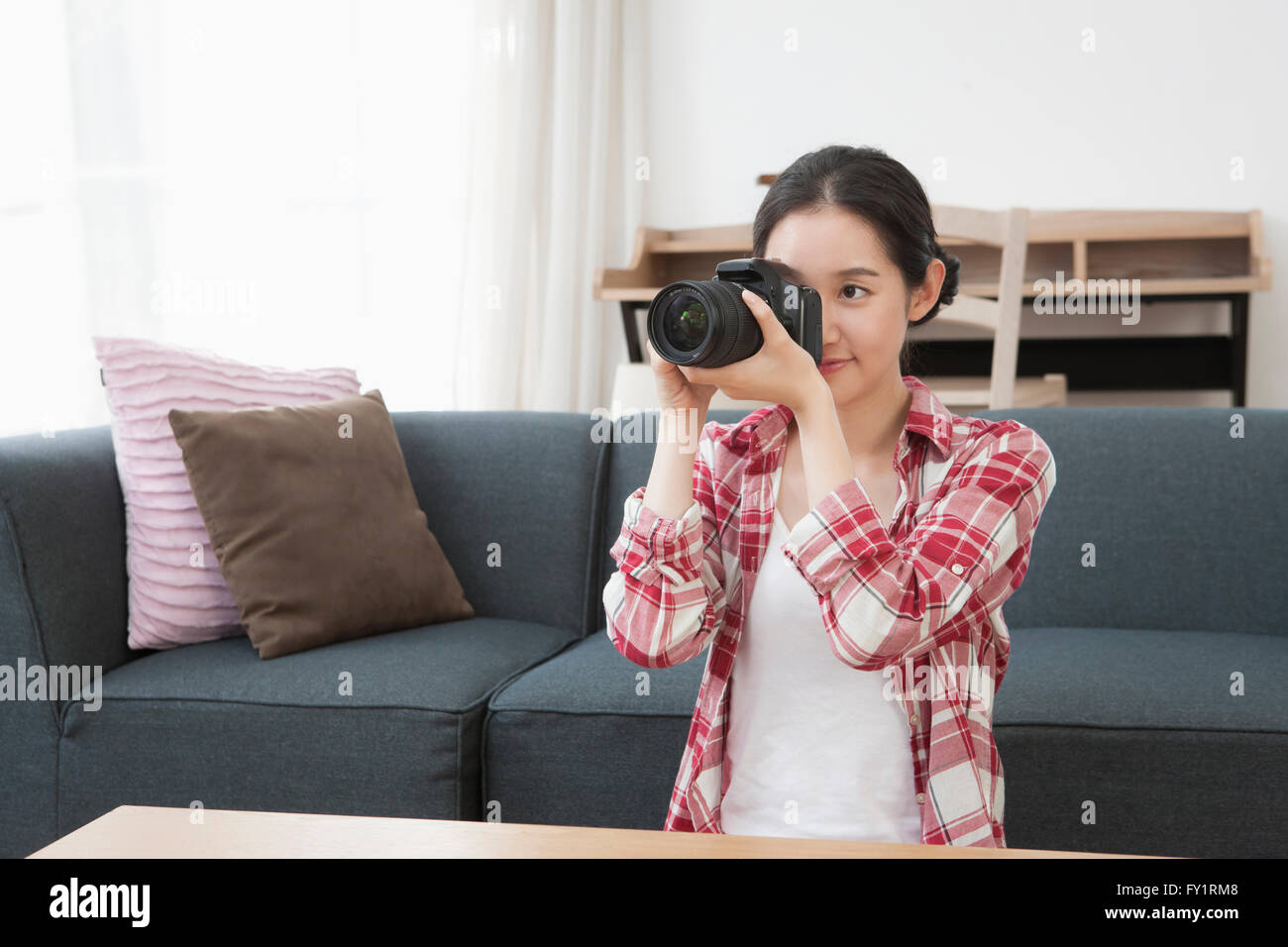 Portrait of young smiling woman holding a camera Banque D'Images