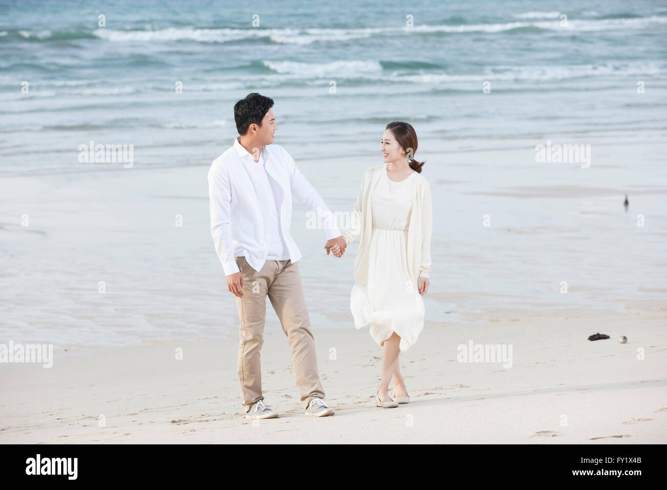Couple marche main dans la main à la plage Banque D'Images