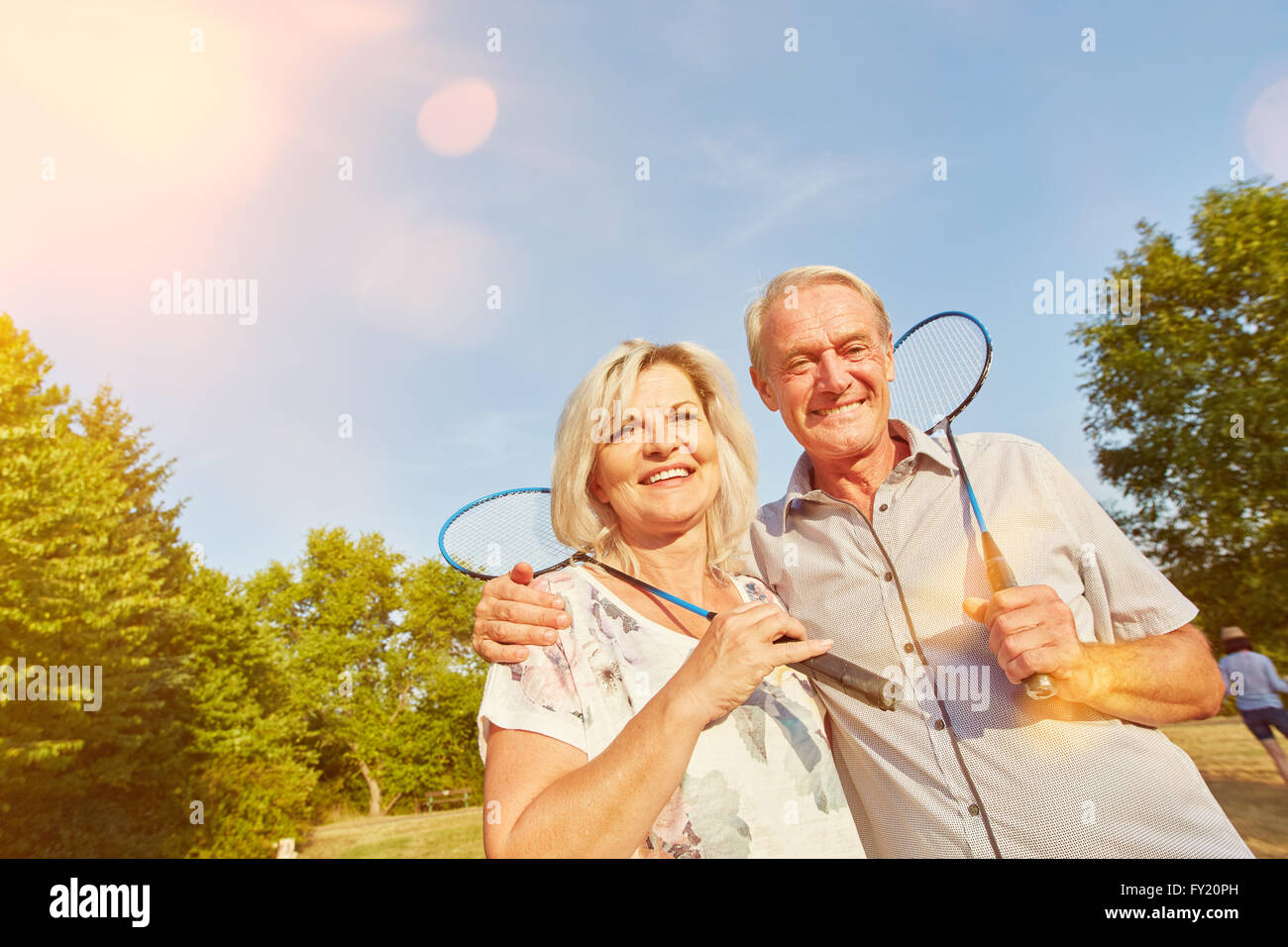 Happy senior couple tandis que jouer au badminton en été Banque D'Images