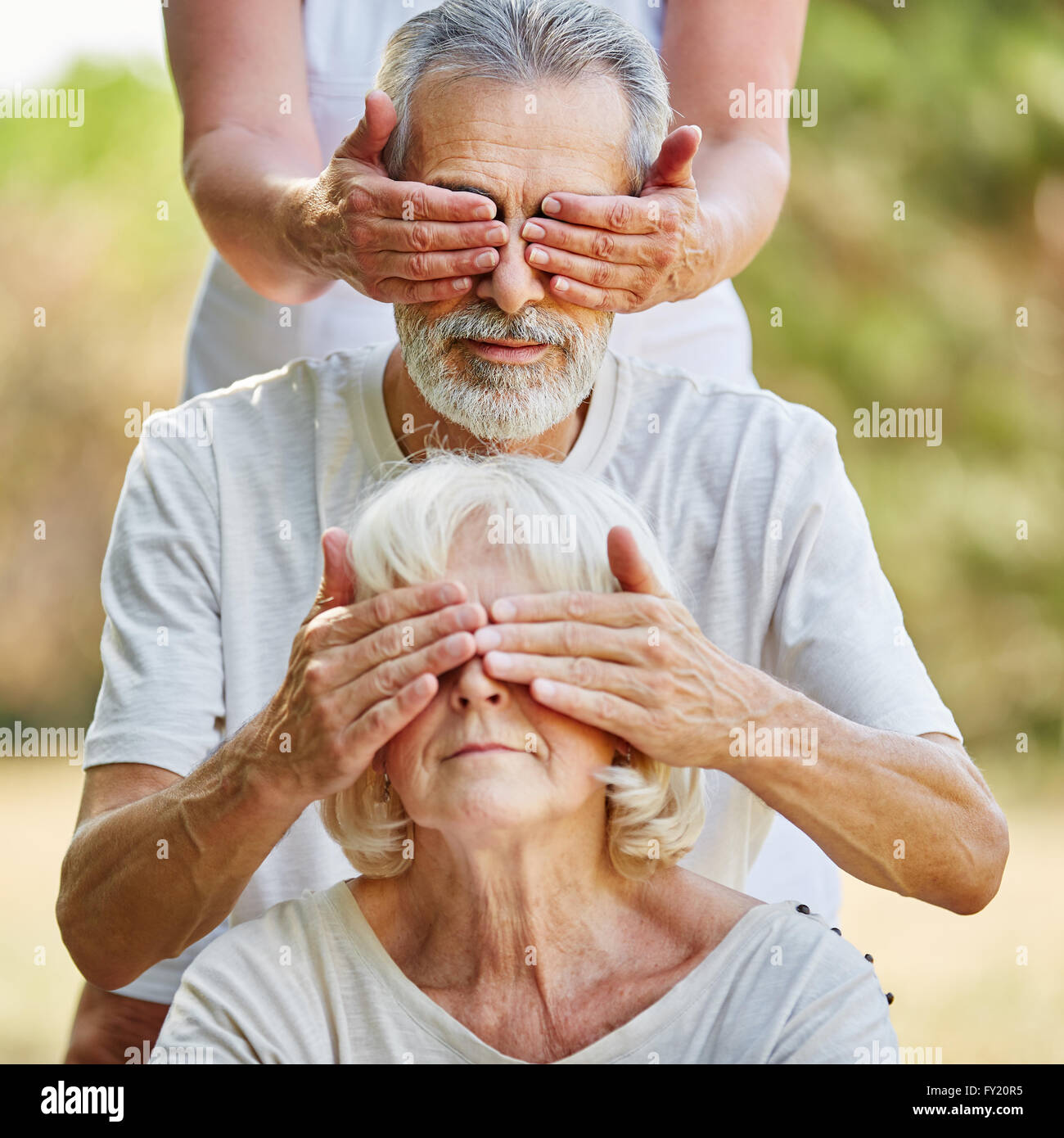Les personnes âgées couvrant les yeux de l'arrière dans le jardin en été Banque D'Images